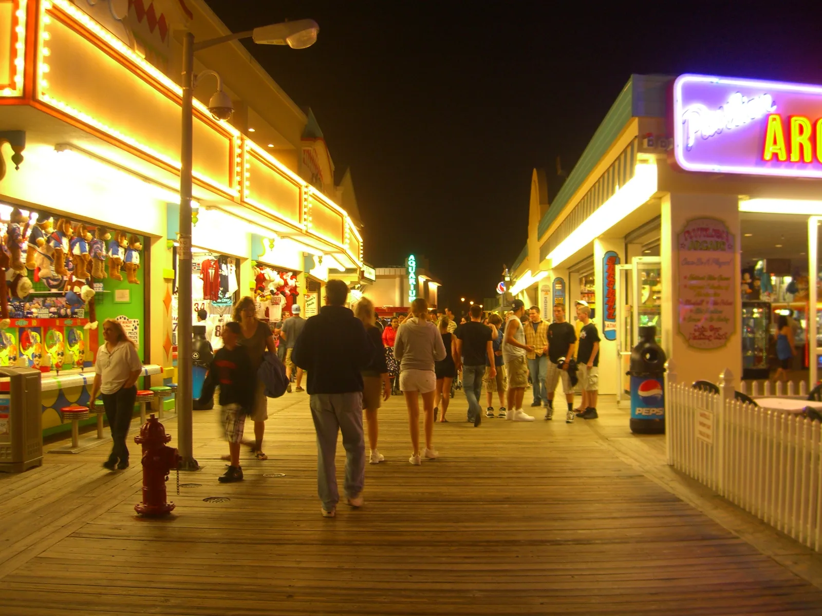 Arcades and food stands glowing along the Point Pleasant Beach boardwalk in the evening