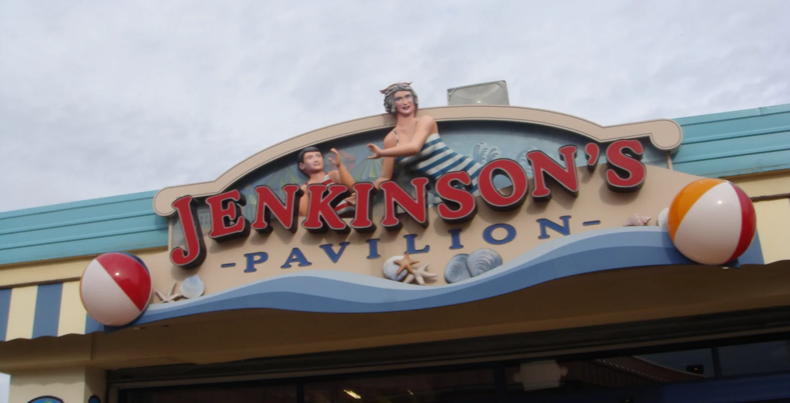 The Jenkinson's Pavilion sign with a vintage bathing-beauty figure and beach balls above the entrance