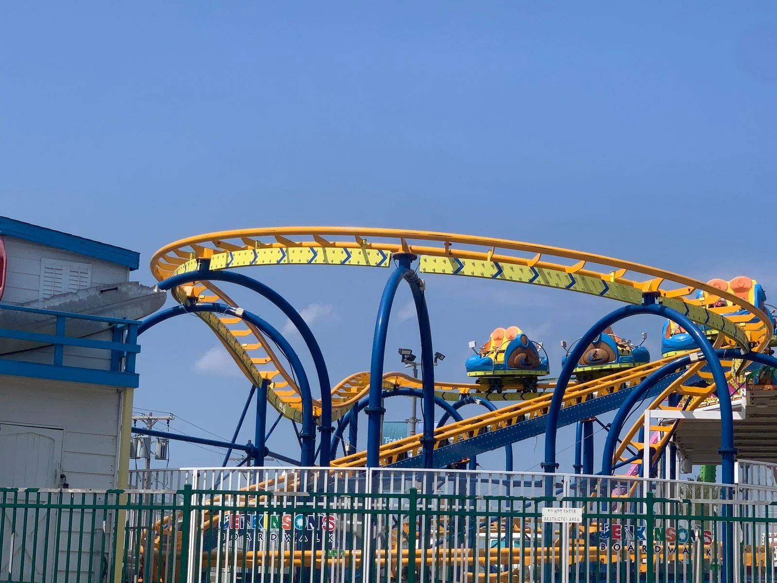 The yellow and blue Tidal Wave roller coaster at Jenkinson's amusement park under a clear blue sky