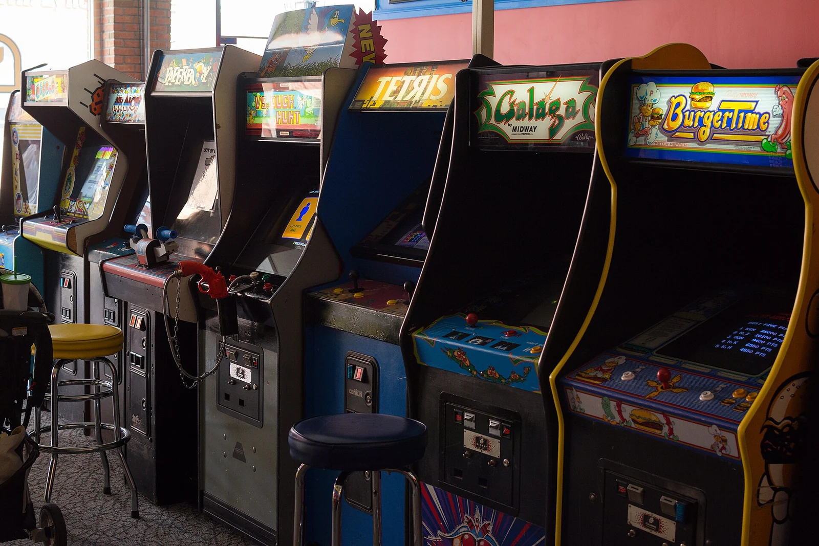 A row of classic arcade cabinets including Tetris, Galaga and BurgerTime at Yestercades