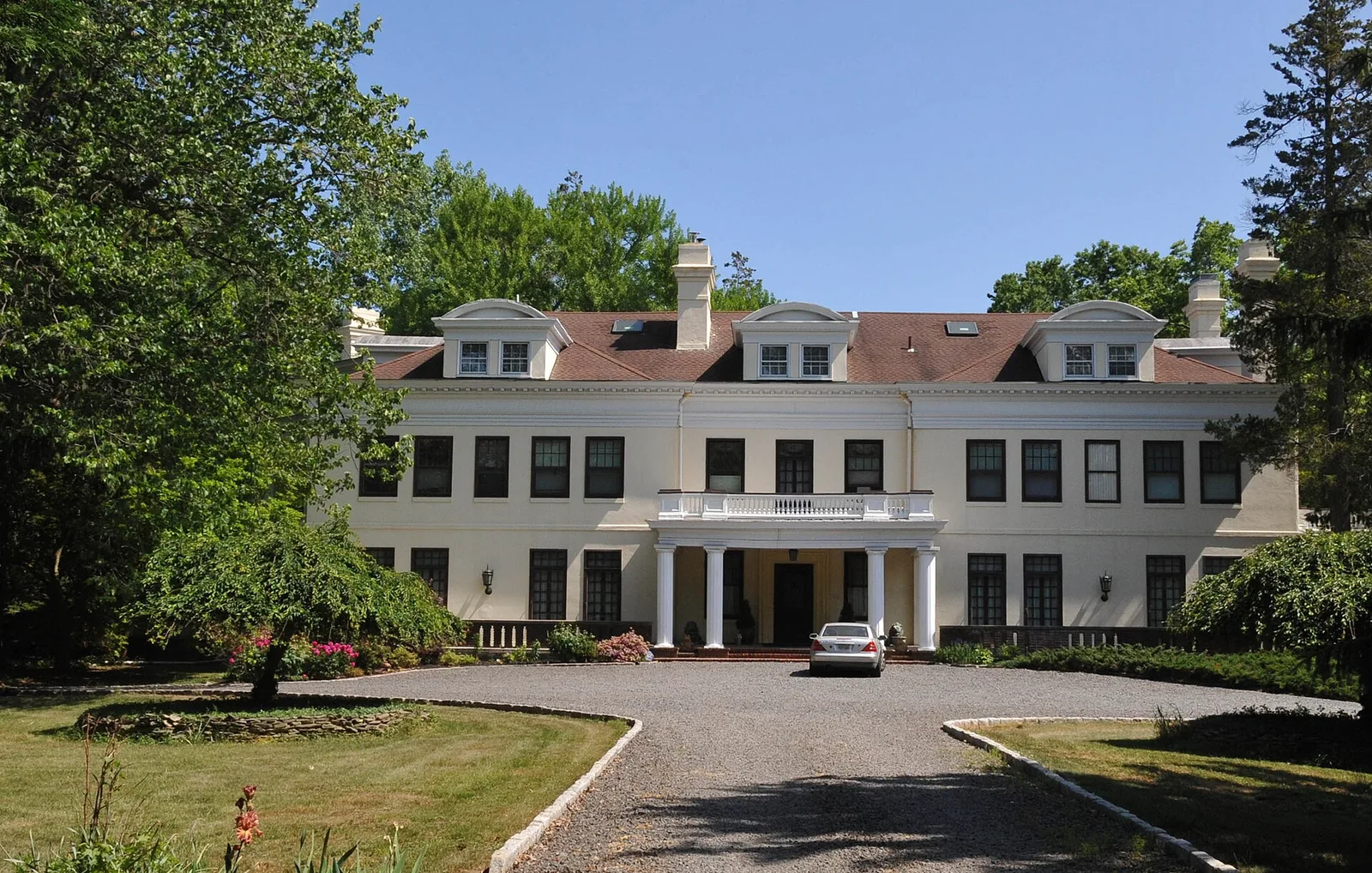Lauriston, a large cream-colored mansion with a columned entrance and a circular drive, in Rumson