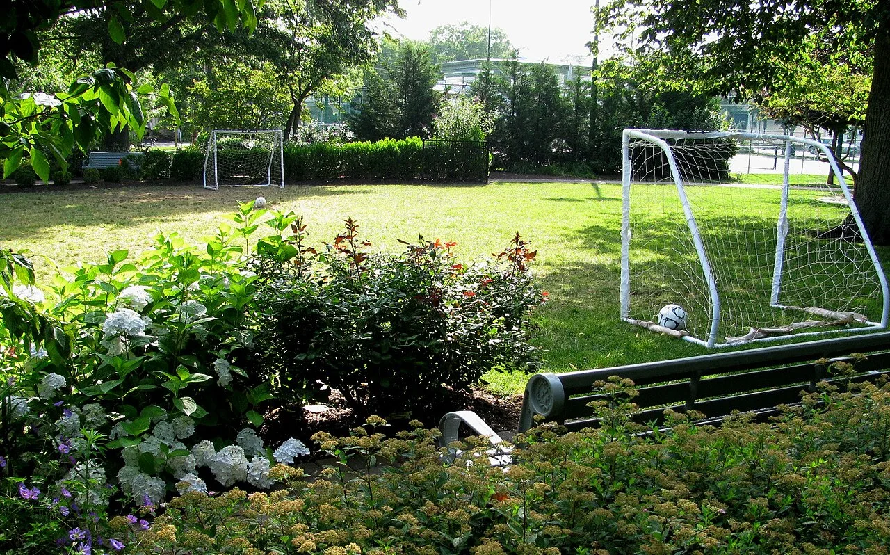A green lawn with soccer goals, flower beds and shade trees at Victory Park in Rumson