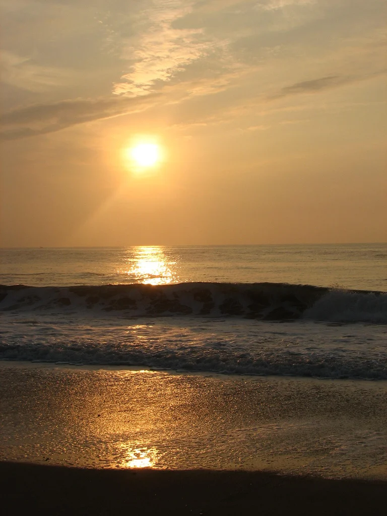 The sun rising over gentle waves at Sea Bright beach on an early summer morning