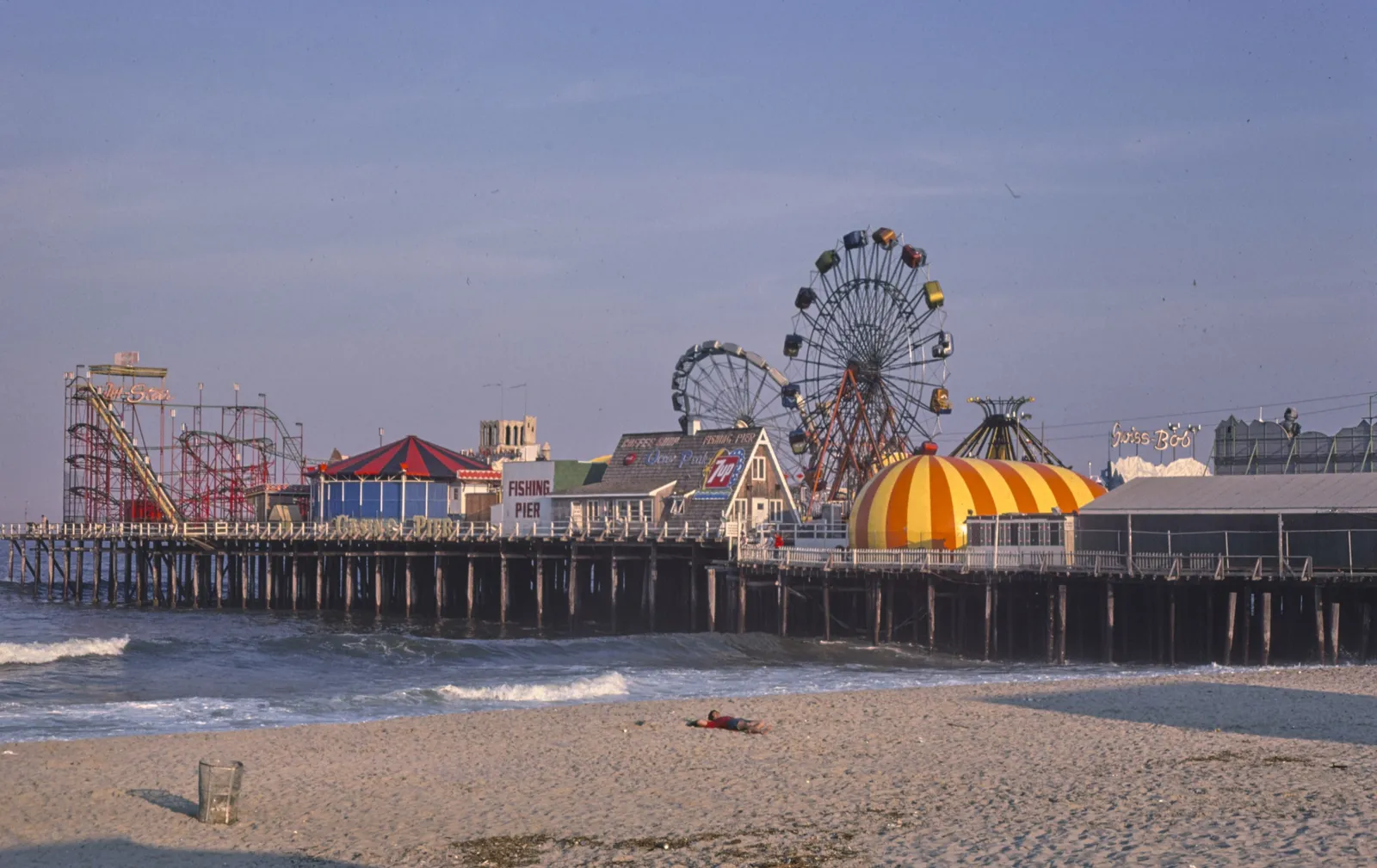 Casino Pier with its Ferris wheels, coaster and striped dome rising over the beach in late-day light
