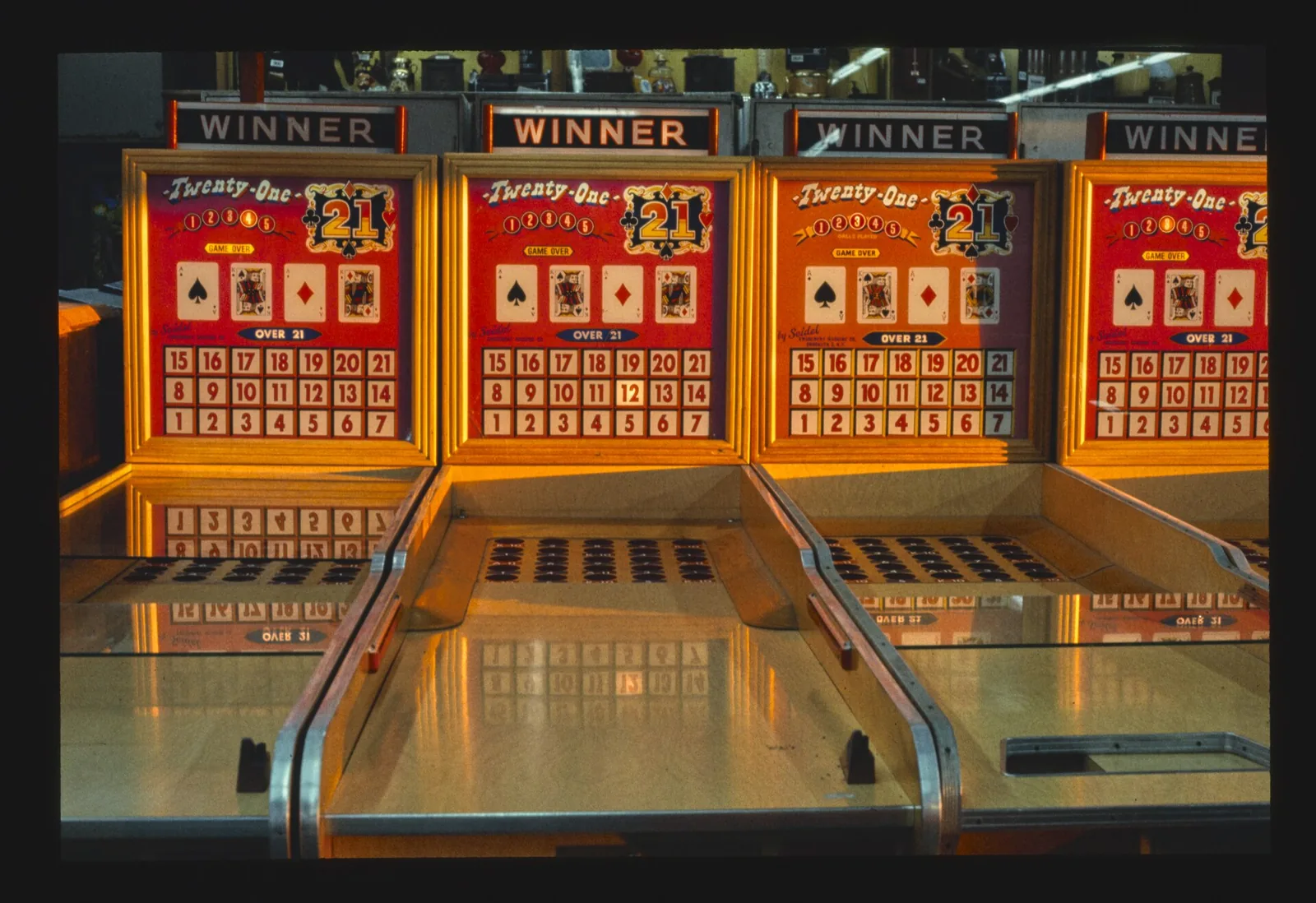 A row of vintage Twenty-One arcade games glowing on the Seaside Park boardwalk in 1978
