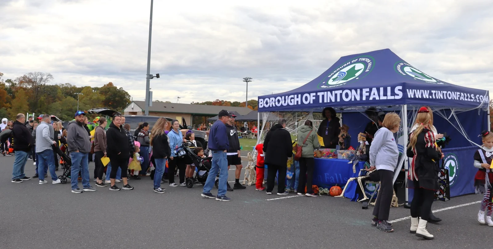 Costumed visitors line up at the Borough of Tinton Falls tent on an autumn afternoon