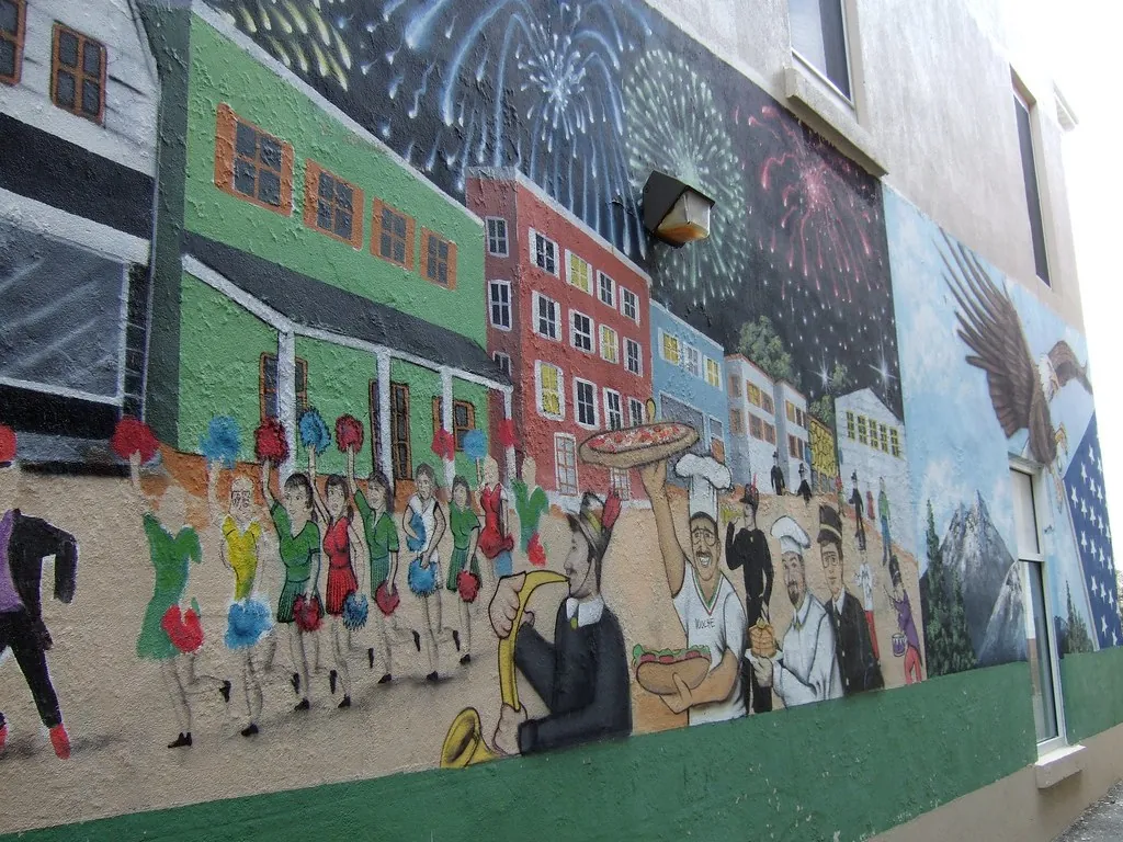 Colorful painted mural of a parade and storefronts on a downtown Toms River wall