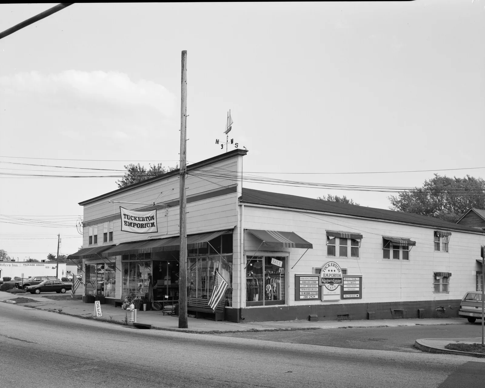 The Tuckerton Emporium, a long two-story storefront on a Main Street corner, in black and white