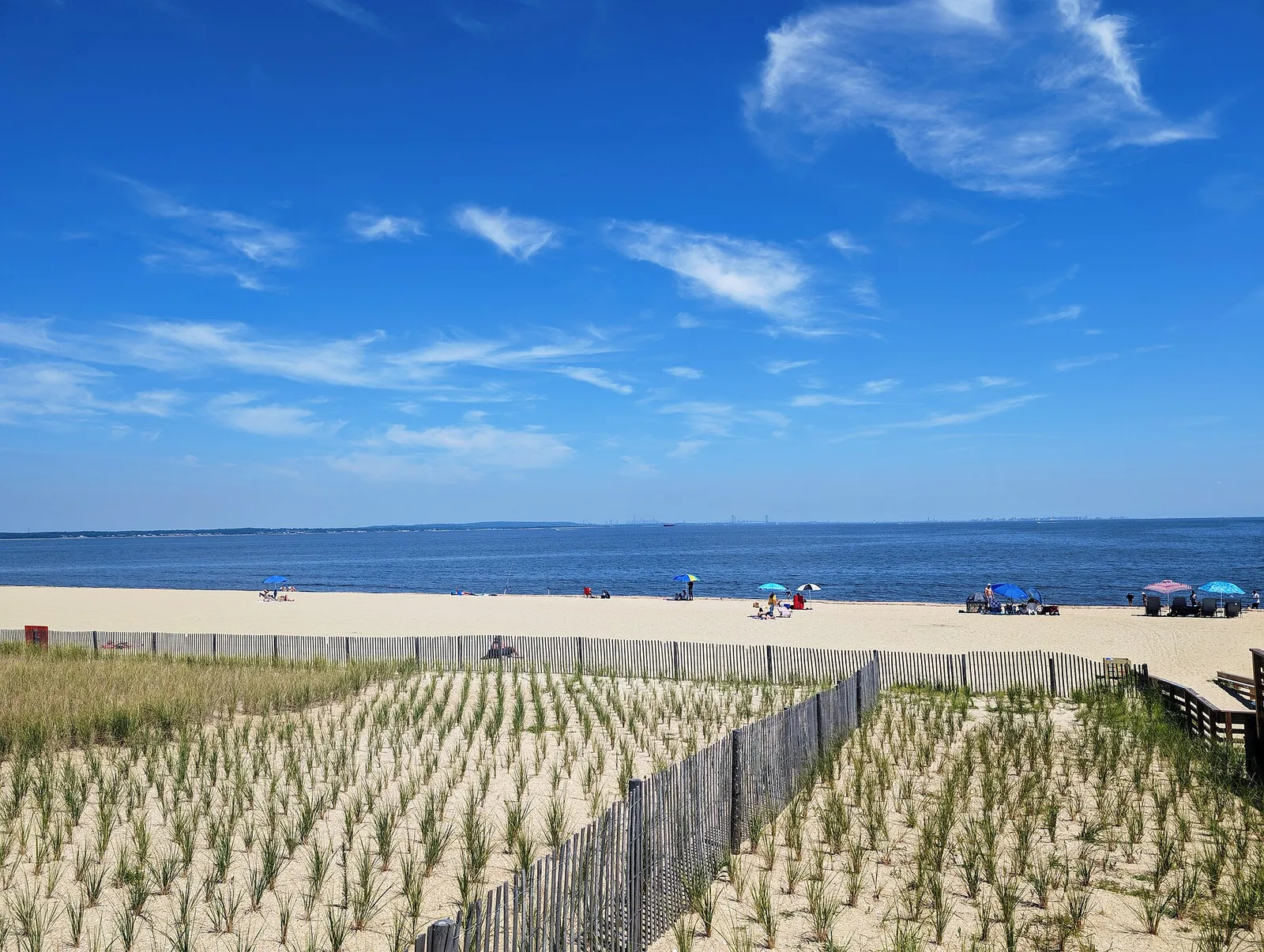Union Beach's sandy bayfront beach on Raritan Bay, with rows of new dune grass behind a split-rail fence