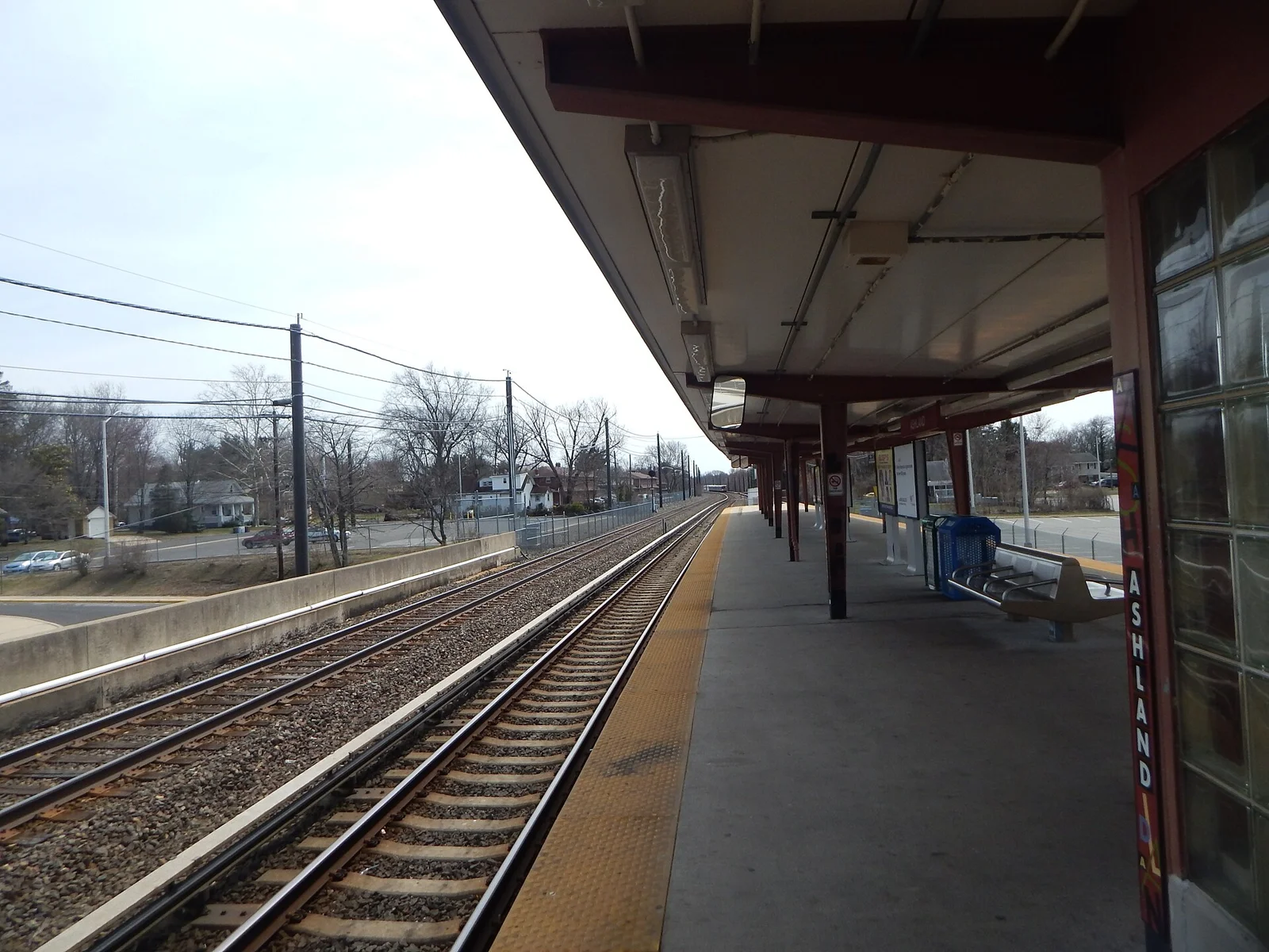The covered platform of PATCO's Ashland station beside the tracks on a clear day