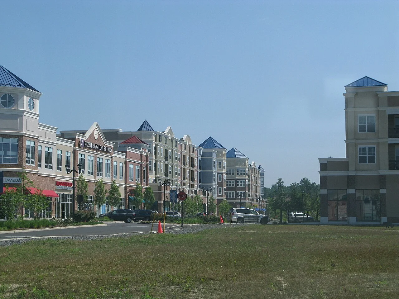 A green lawn leading to the shops and residences of the Voorhees Town Center