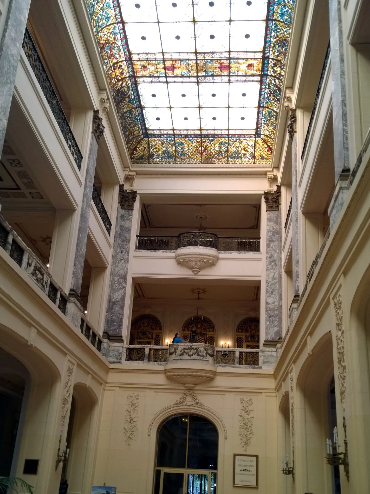 Looking up through the carved balconies of Wilson Hall's central atrium to a stained-glass skylight