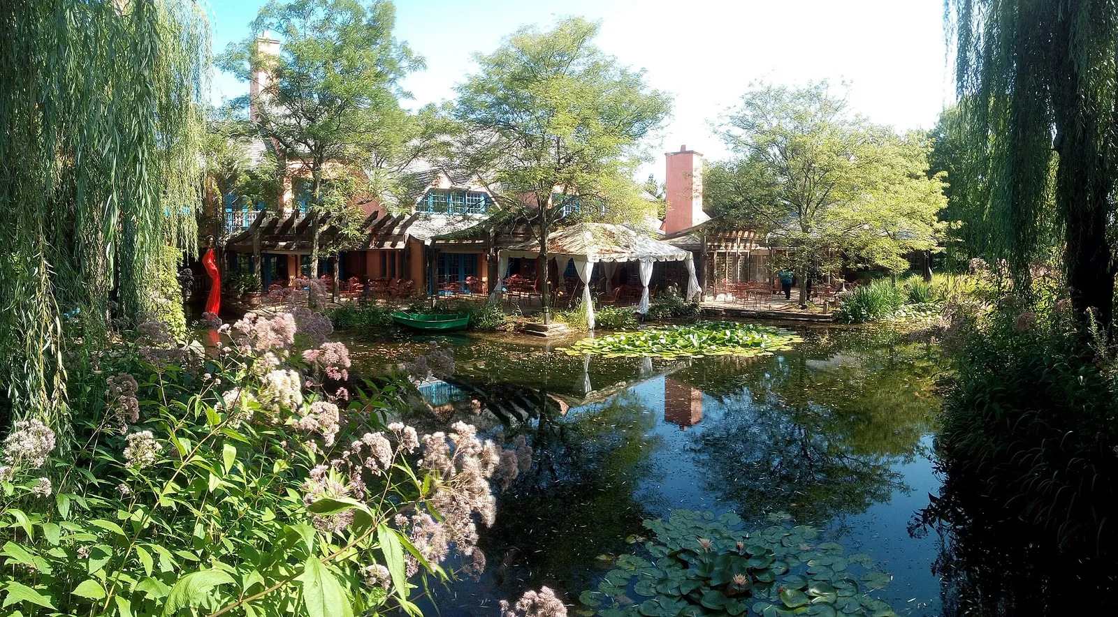 Pond, water lilies and a restaurant building among willows at Grounds For Sculpture