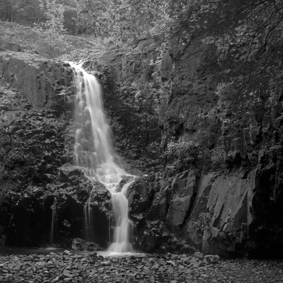 Black and white photo of Hemlock Falls spilling down a rock wall