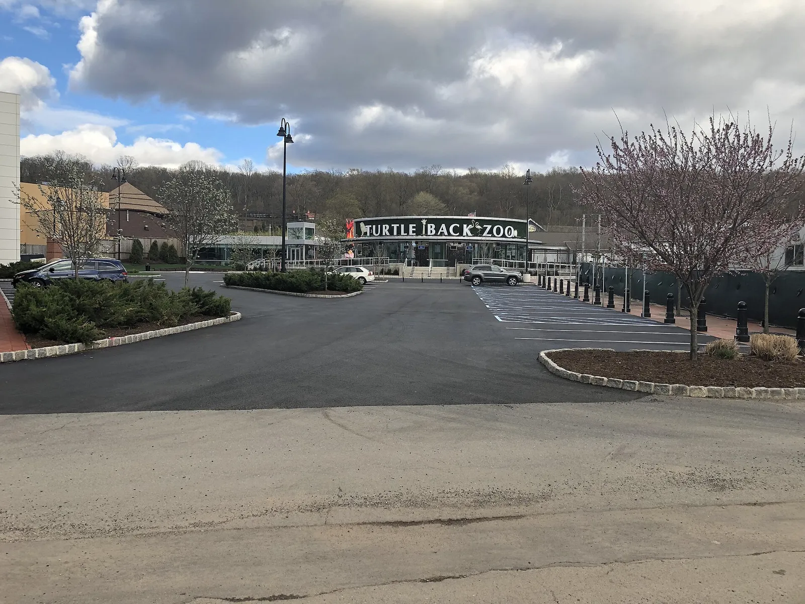The Turtle Back Zoo entrance sign seen across a parking lot