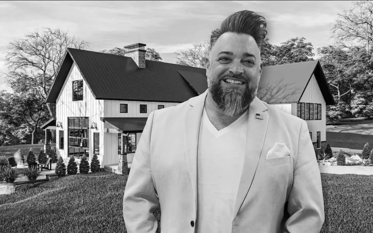 Dennis Mark Interdonato in front of a farmhouse, in black and white