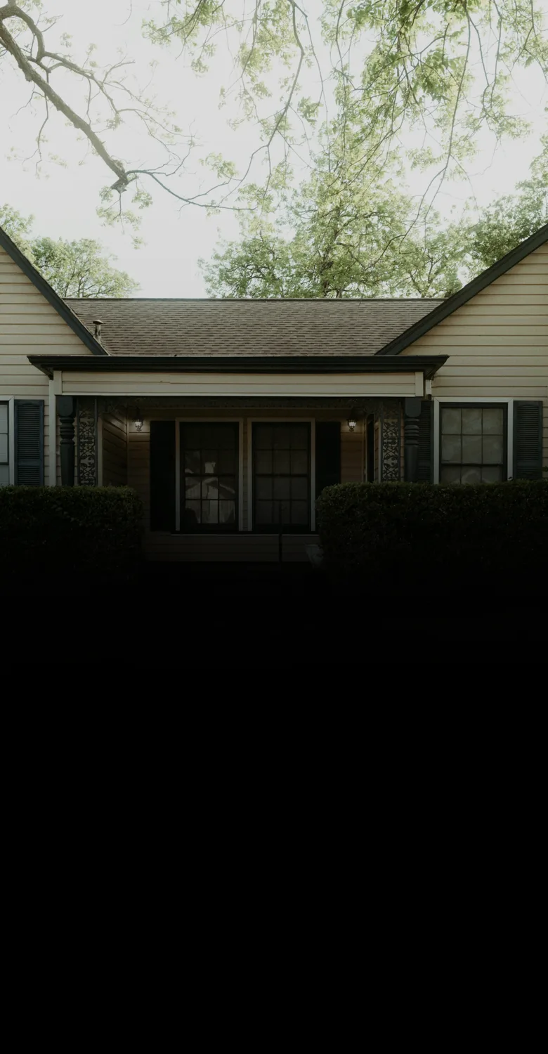 A single-story home with a covered porch behind trimmed hedges, fading into a fine-line drawing of a clubhouse with a cupola, a gazebo and a path leading to the door