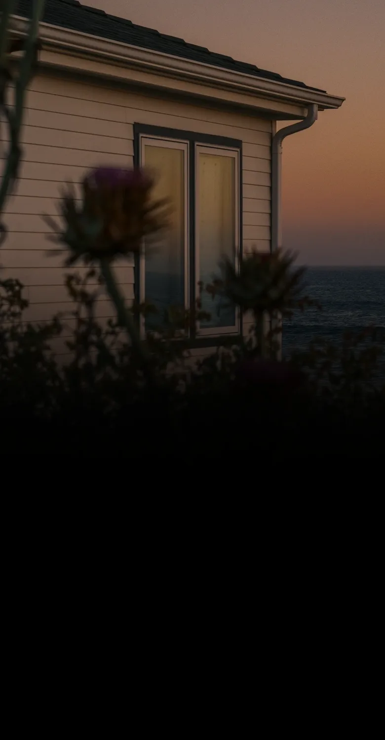 A coastal home above the ocean at sunset, fading into a fine-line drawing of a compass, a dotted route and a home with a red pin