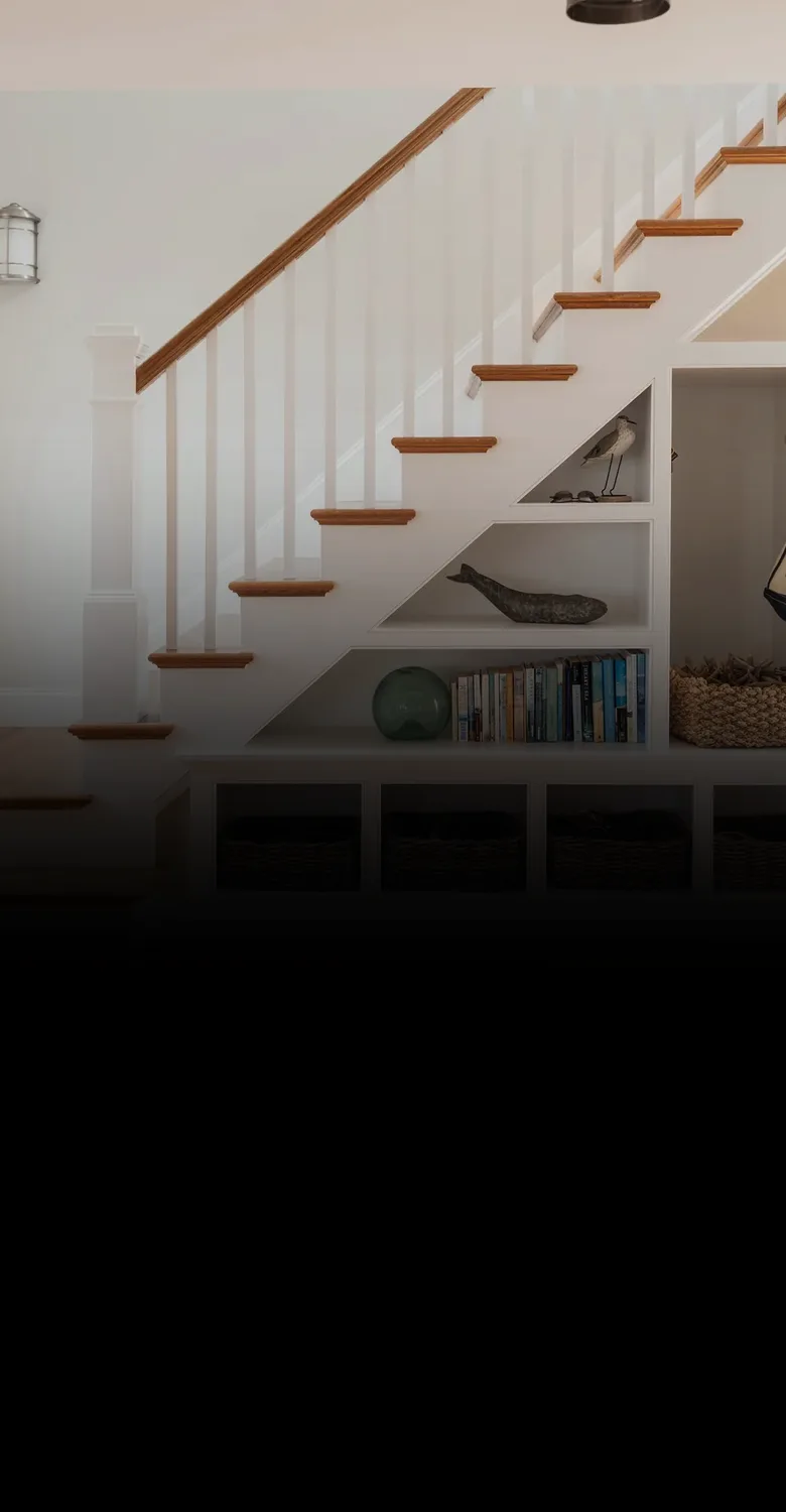 A staircase with built-in shelves, fading into a fine-line drawing of a two-family home beside a rising red line